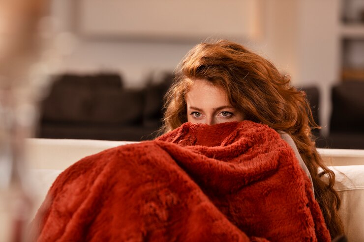 close-up-woman-covering-herself-with-blanket_23-2149172488